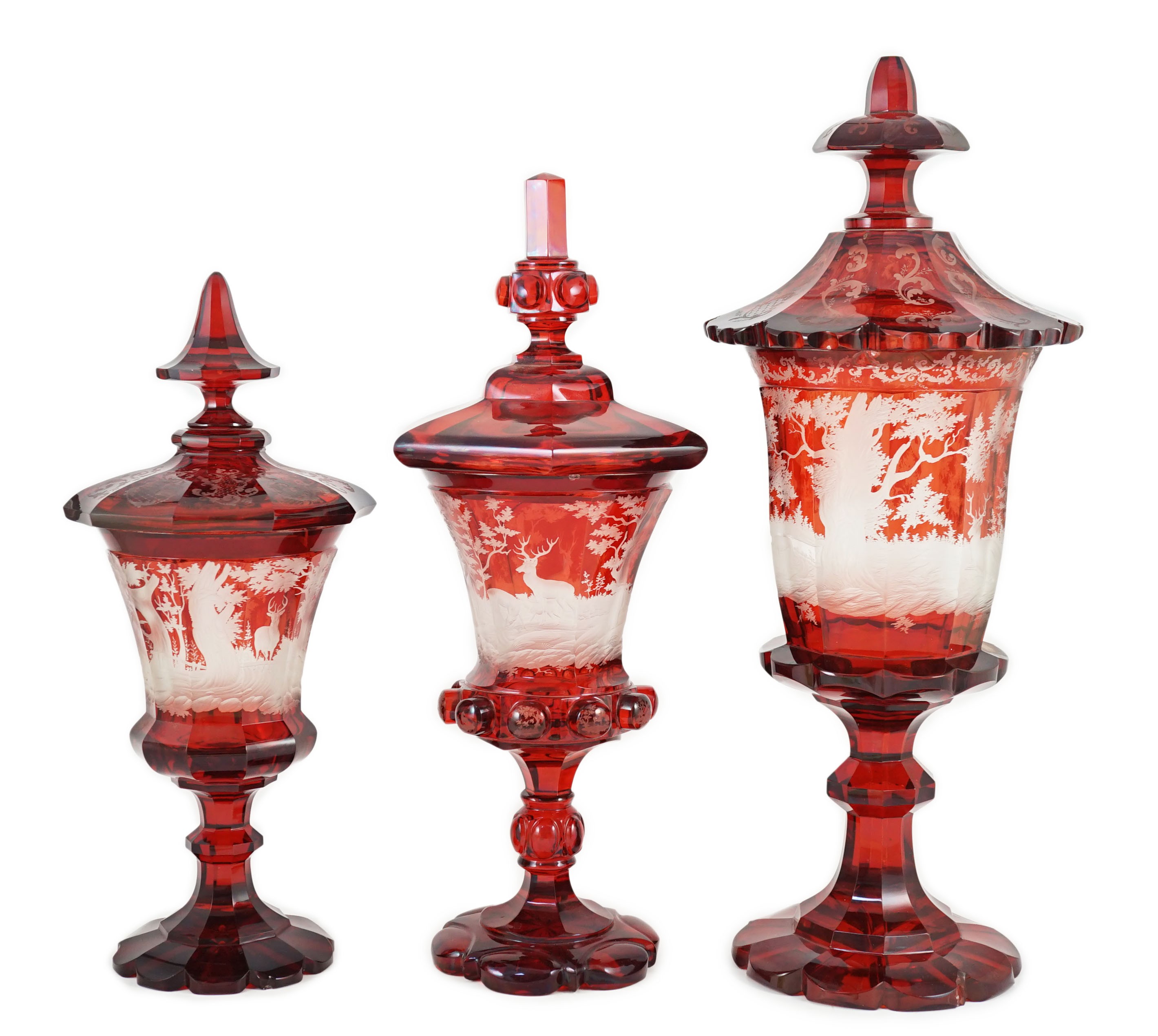 Three large Bohemian ruby stained glass goblets and covers, late 19th century, 38.5cm to 50.5cm high, rim chips